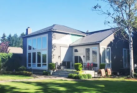 Modern home exterior with metal and shingle roof combination, Alamo Roofing